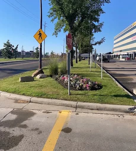 Annual flower bed, boulders and grasses brightening a busy street corner.