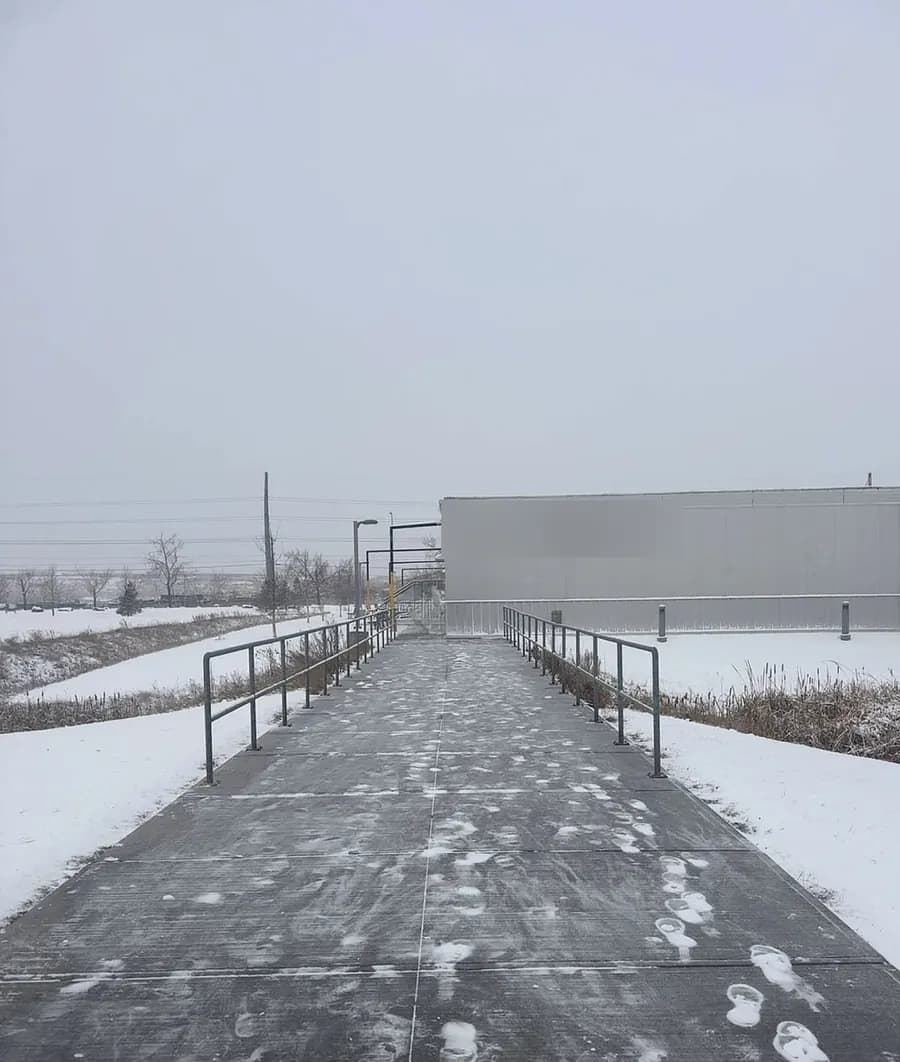 Rampe d’accès d’un immeuble de bureaux, dégagée d’une rampe à l’autre pour marcher en sécurité.